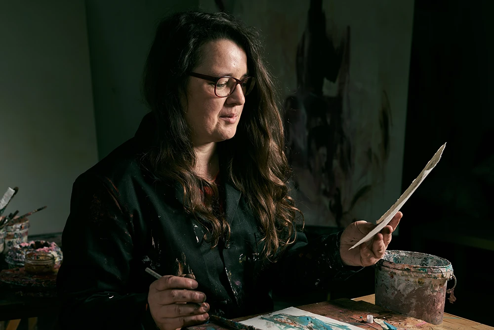 Künstlerin Monika Herschberger studiert eine von ihr gefertigte Skizze